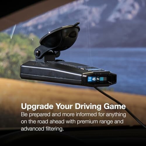 Car radar detector mounted on windshield with display screen.